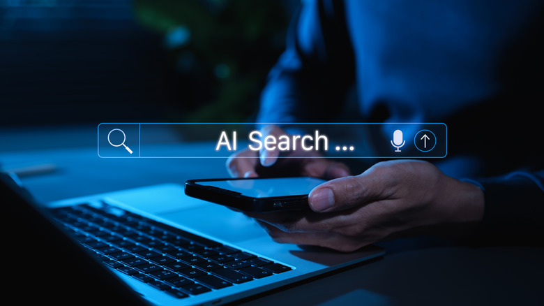 A man begins to type into an AI search bar on his phone and laptop.