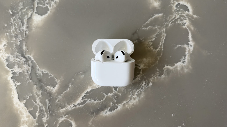 AirPods 5 in case with lid open on marble surface