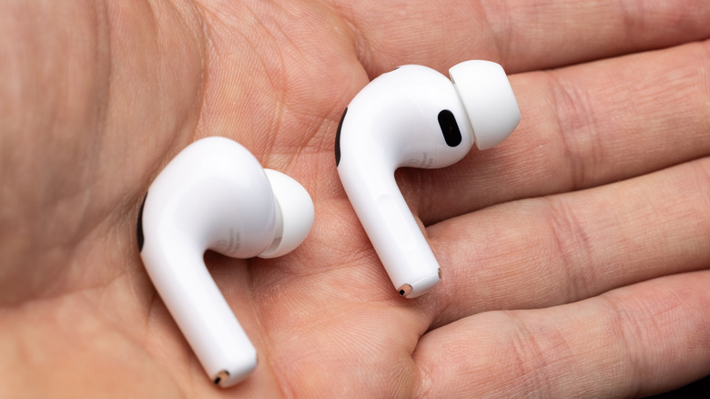 AirPods Pro 3 earbuds in hand.