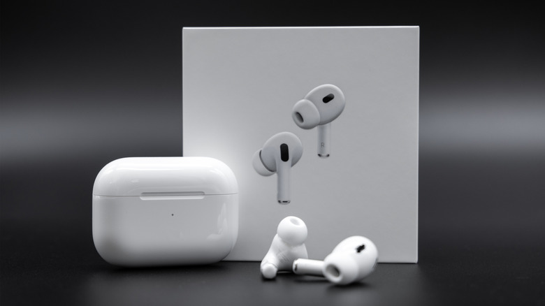 AirPods Pro 2 earbuds next to charging case and retail box.