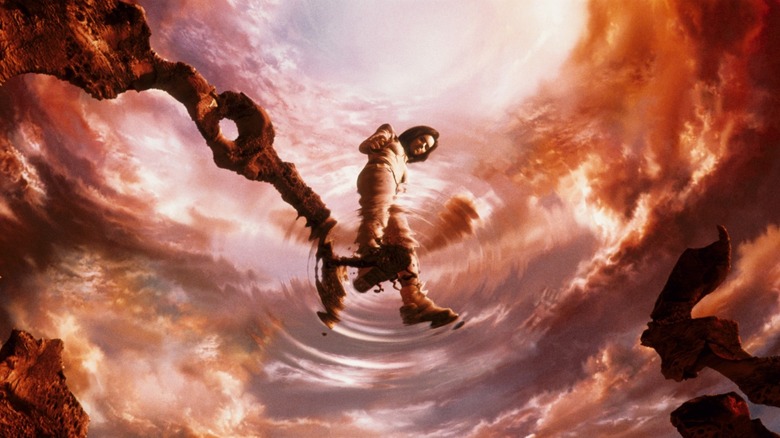 Aki Ross standing in the center of red pool looking down at ripples