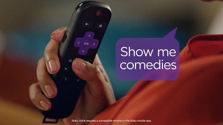 Woman holding Roku remote and using Roku voice command