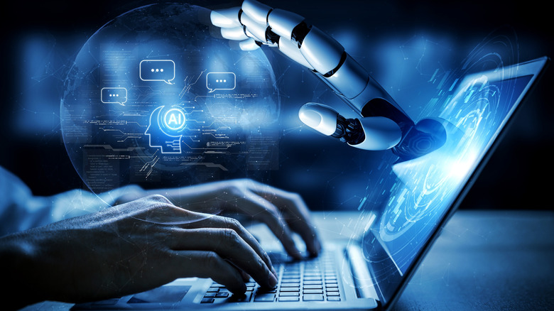 A person typing on a laptop with a robotic arm emerging from the screen to represent AI
