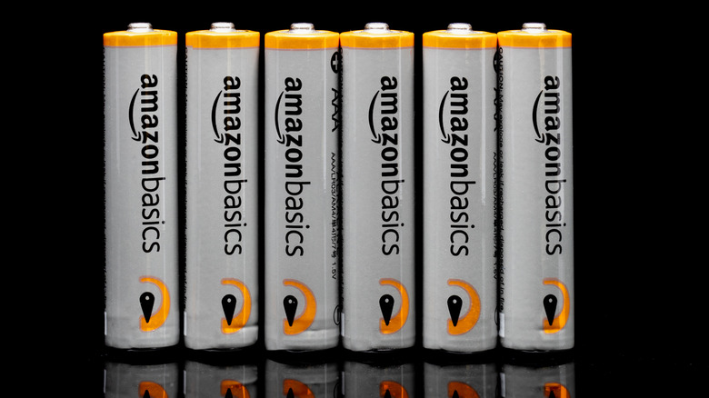 Several Amazon Basics batteries over a black background