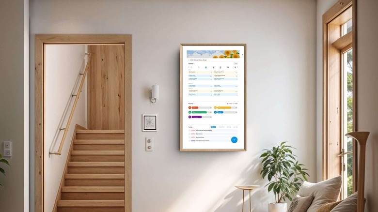 The ApoloSign smart calendar hanging on a wall in a modern minimalist living room
