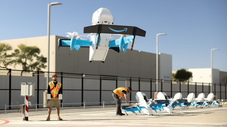 An Amazon drone taking off as an employee looks