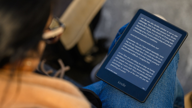 A person reading a Kindle on their lap