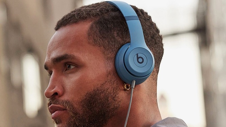Man wearing the slate blue Beats Solo 4 headphones.