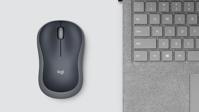 A top-down view of the Swift Gray Logitech next to a gray laptop, both are on a gray backdrop