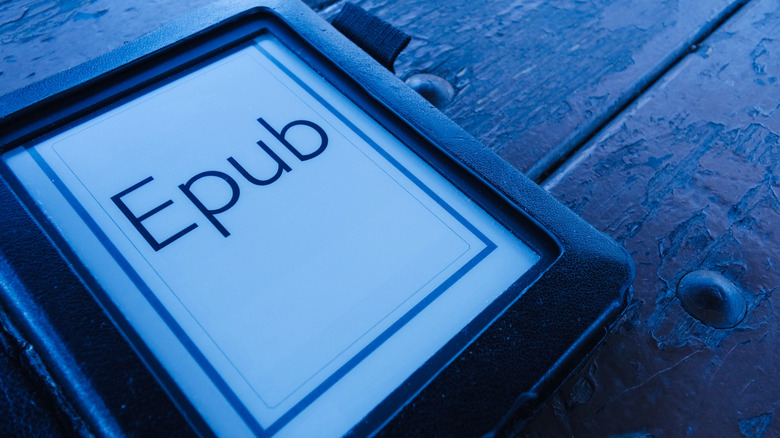 An e-reader sitting on a picnic table with the word "Epub" writting on the screen