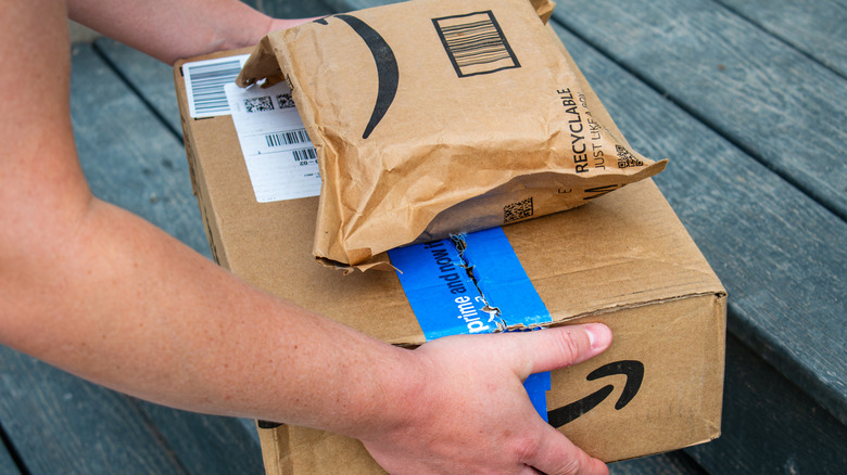 A person picking up Amazon packages that have been delivered