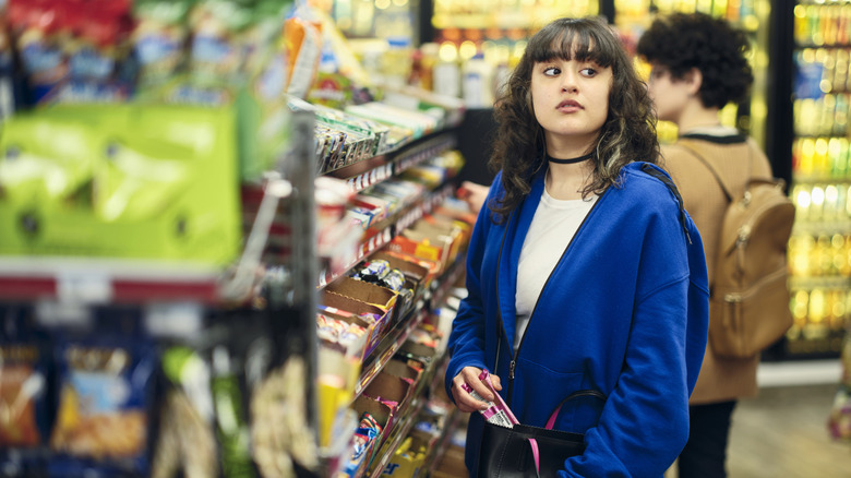 a woman shoplifting at a grocery store