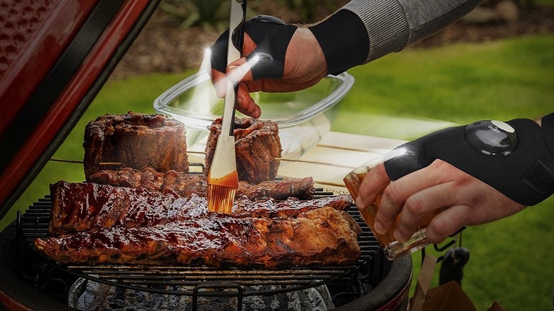 Parigo hands-free gloves with LED lights used to grill food at night.
