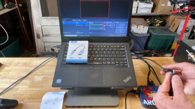 An image showing the BENFEI capture card in use, attached to a ThinkPad