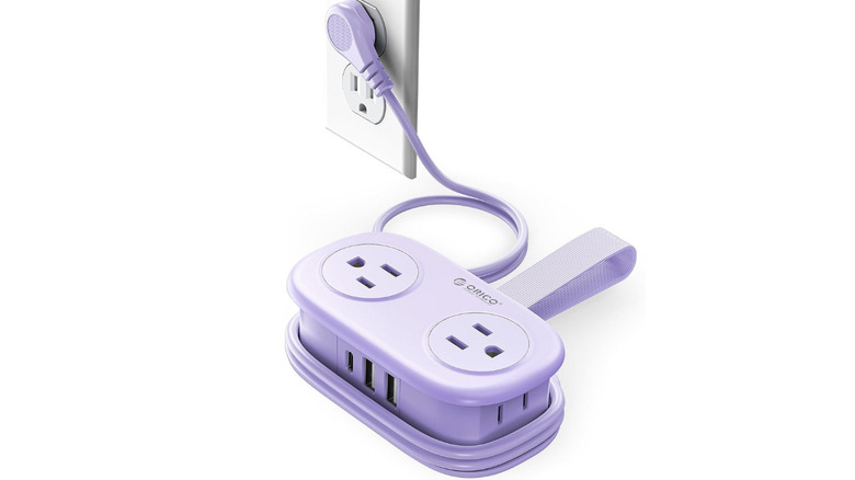 Purple ORICO travel power supply plugged into wall outlet