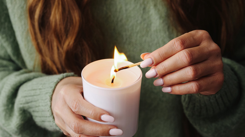 Woman lighting candle with matchstick