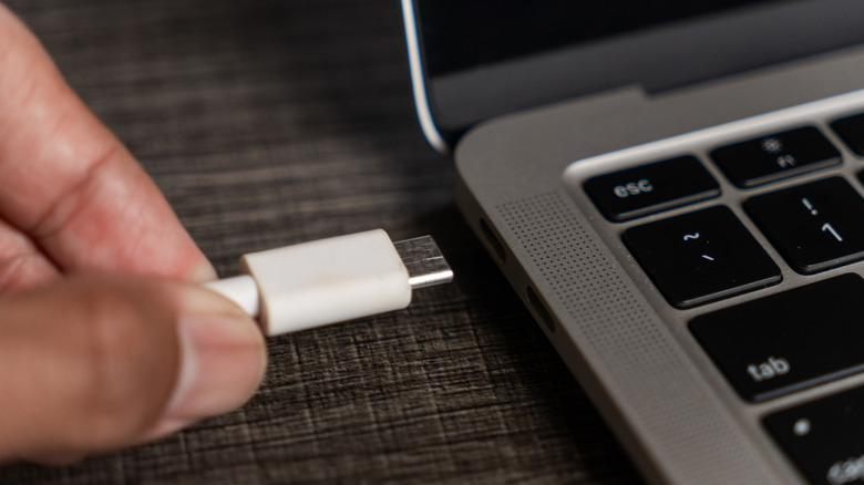 Hand plugging a cable into a USB-C port