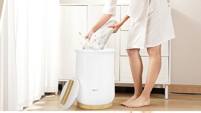 Woman putting towels inside Keenray Towel Warmer Bucket