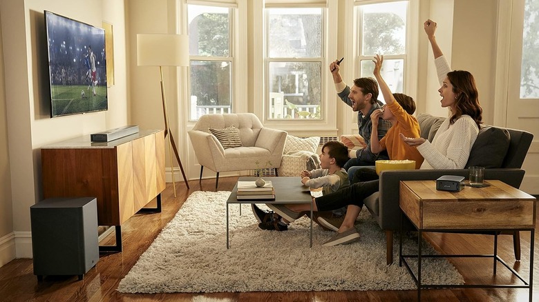 The JBL Bar 9.1 Soundbar System set up in a living room. A family watches a soccer game, cheering for their team.