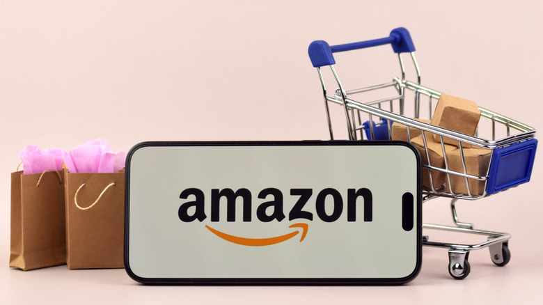 The Amazon logo displayed on a smartphone alongside shopping bags and packages