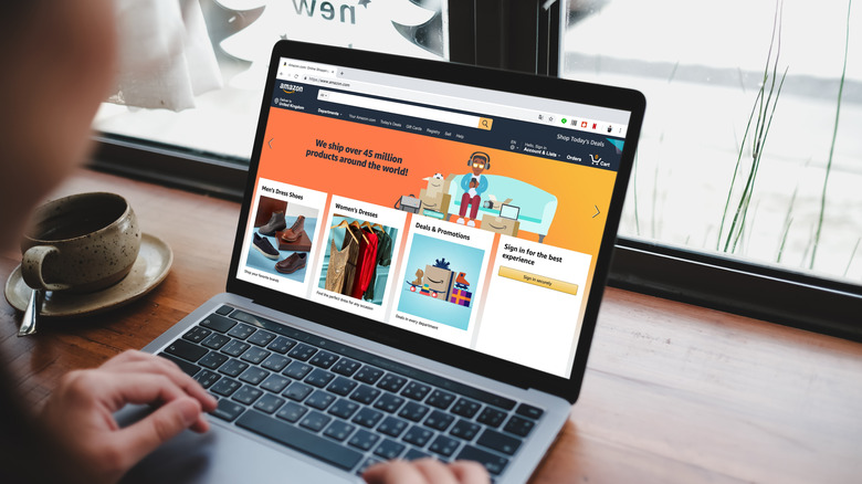 person in coffee shop looking at Amazon home page for deals