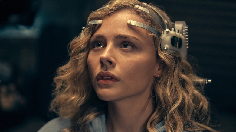 Flynne (Chloe Grace Moretz) wearing a head device on 