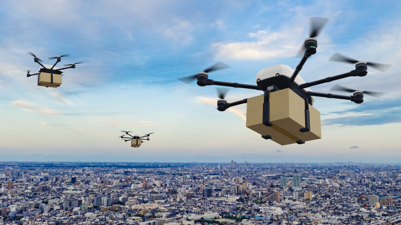 delivery drone concept, three dones flying over city with boxes underneath