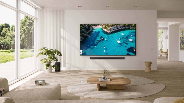 Samsung DU9000 Crystal 4K 98-inch smart TV mounted on a wall in a living room.