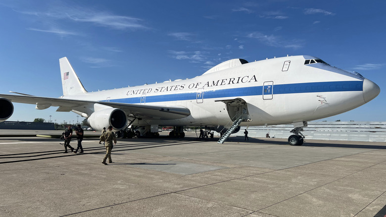 Several Air Force members walk towards a grounded E-4B