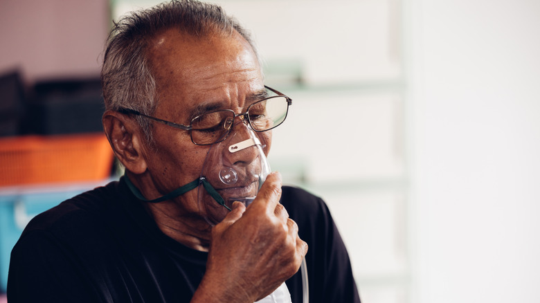 an elderly man wearing an oxygen mask