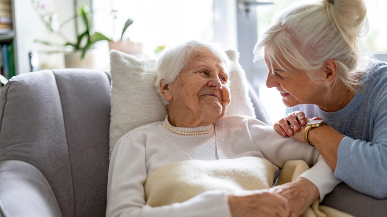 two senior women smiling at one another