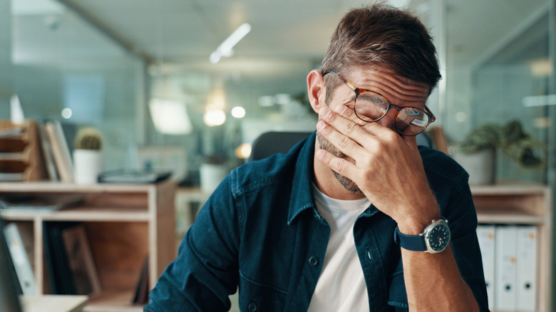 frustrated man rubbing his eyes, frustrated concept