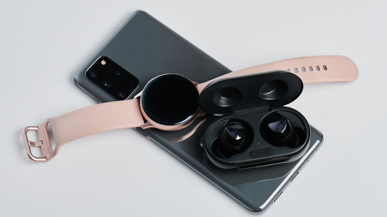 A smartphone and earphones on the back of an android being charged