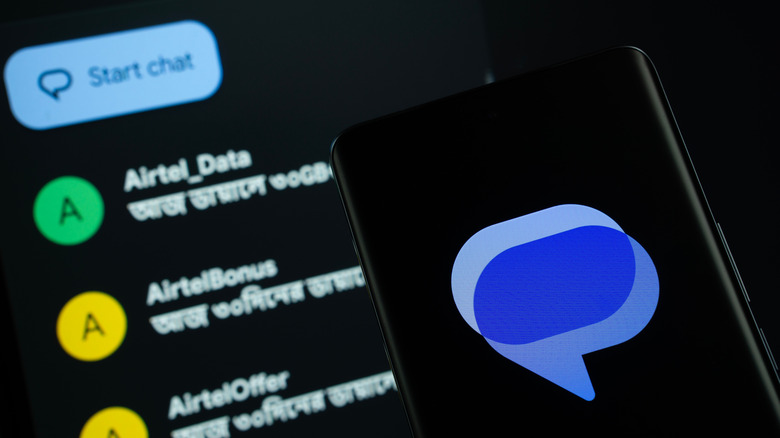 Google messages logo on a smartphone with the app also open in the background