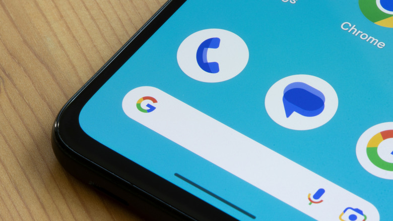 close up of android smartphone with Google Messages icon next to Google Phone icon and Google app