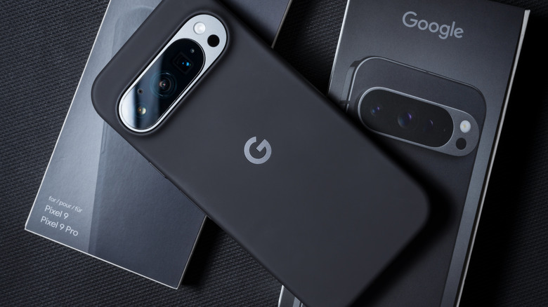 A Google Pixel 9 smartphone inside a black protective case sits on top of a Google Pixel box and the box for said protective case