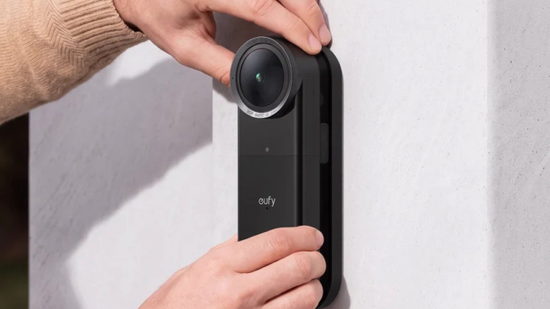 The Eufy Video Doorbell S4 being mounted in place by a person.