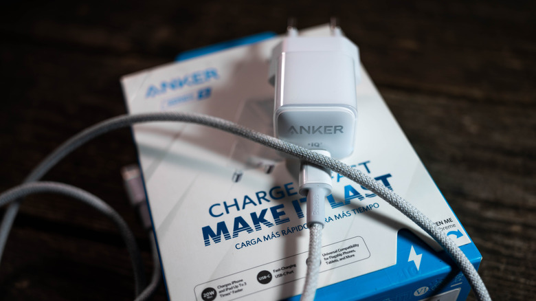 An Anker wall charger on top of its packaging box.
