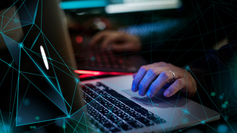 hacking concept, hand on keyboard with digital networks around