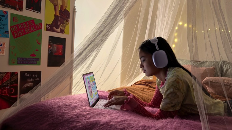 A teenager using a MacBook Neo laptop.