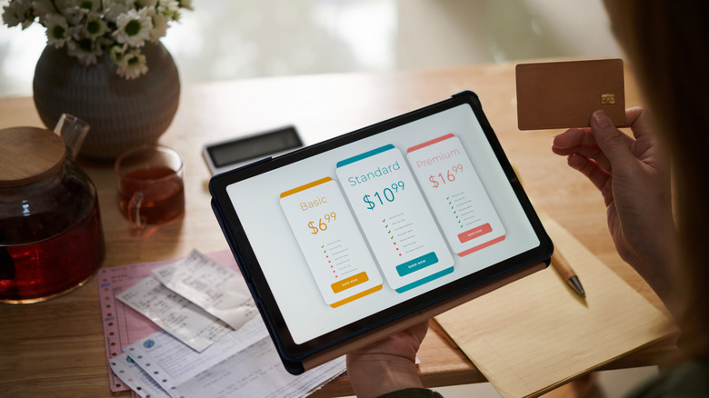 A concept of a consumer choosing between different subscriptions for a product purchased on a tablet.