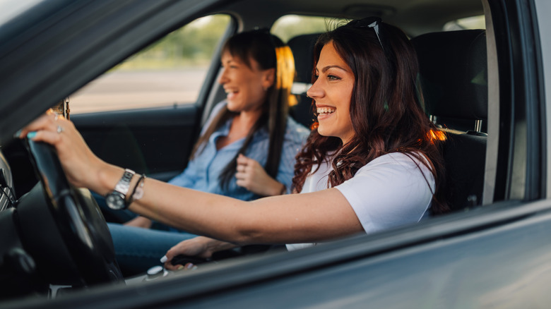 two women happily driving in a car
