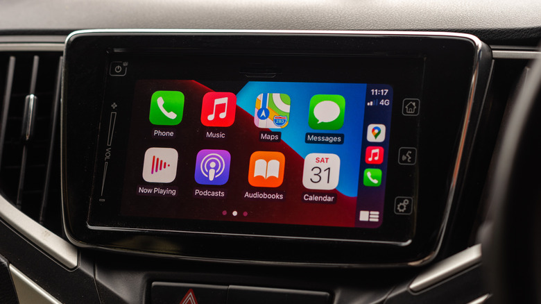 CarPlay apple iOS icons displayed in the interior of a car. Dashboard of a car with CarPlay interface