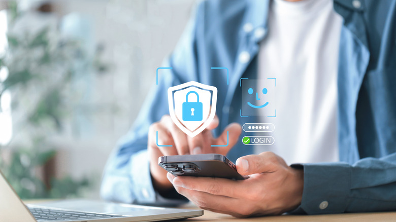 A man in a blue shirt opens the security settings of his iPhone. Blue security and facial ID login symbols hover above the screen.