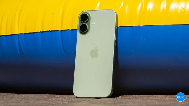 The standard iPhone 17 placed on the ground against an inflatable pool.