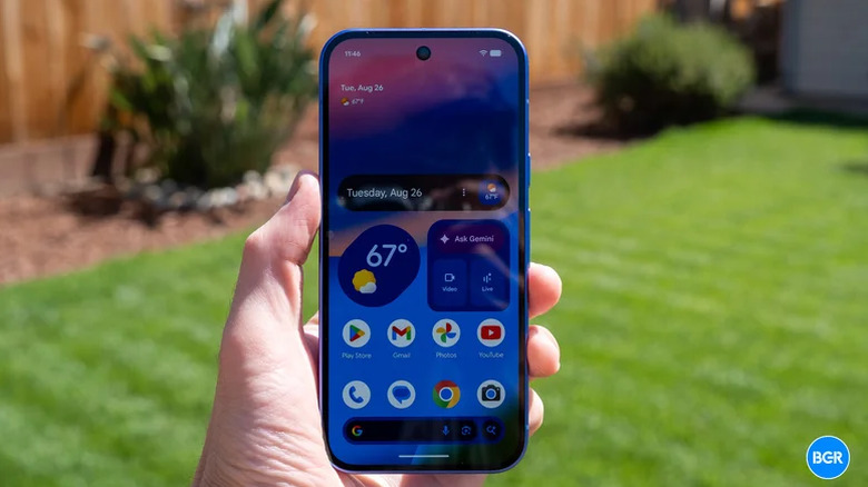The Pixel 10 smartphone in hand, with the display turned on.