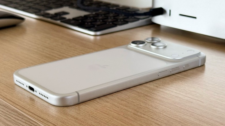 eSIM-only iPhone 17 Pro Max on a tablet. Behind it, a Mac Studio and Magic Keyboard