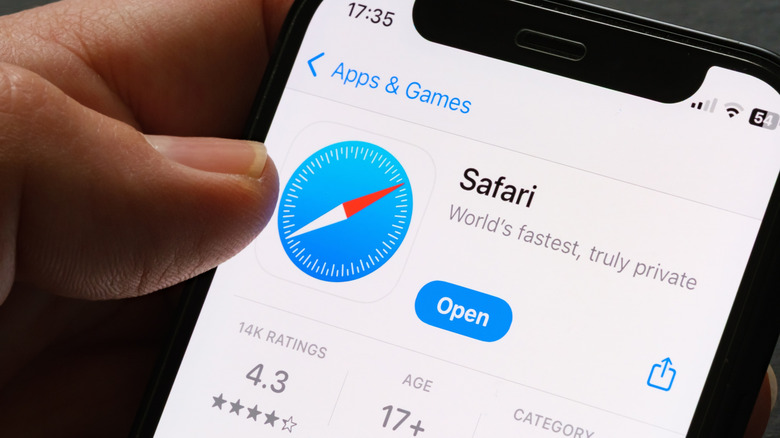 A hand holding an iPhone with the Safari app download page.