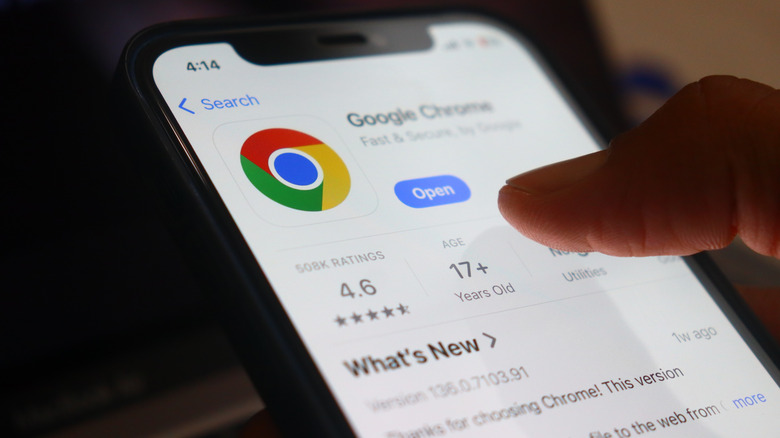 A close-up of an iPhone with a finger about to download Google Chrome.