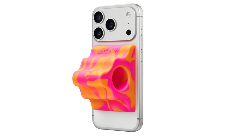 The orange Hikawa Grip & Stand for iPhone attached to the back of a silver iPhone thanks to Mag-Safe